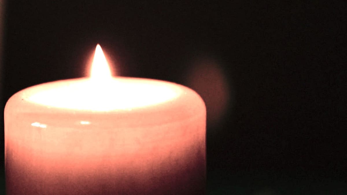 Bougie allumée dans la pénombre, flamme droite